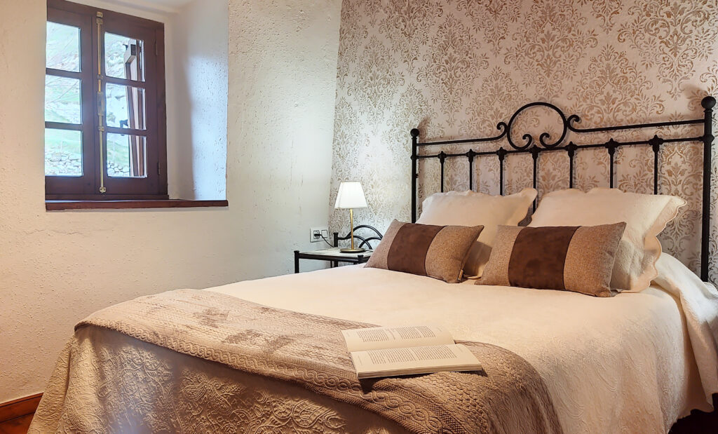 Dormitorio acogedor con cama de hierro y decoración clásica.